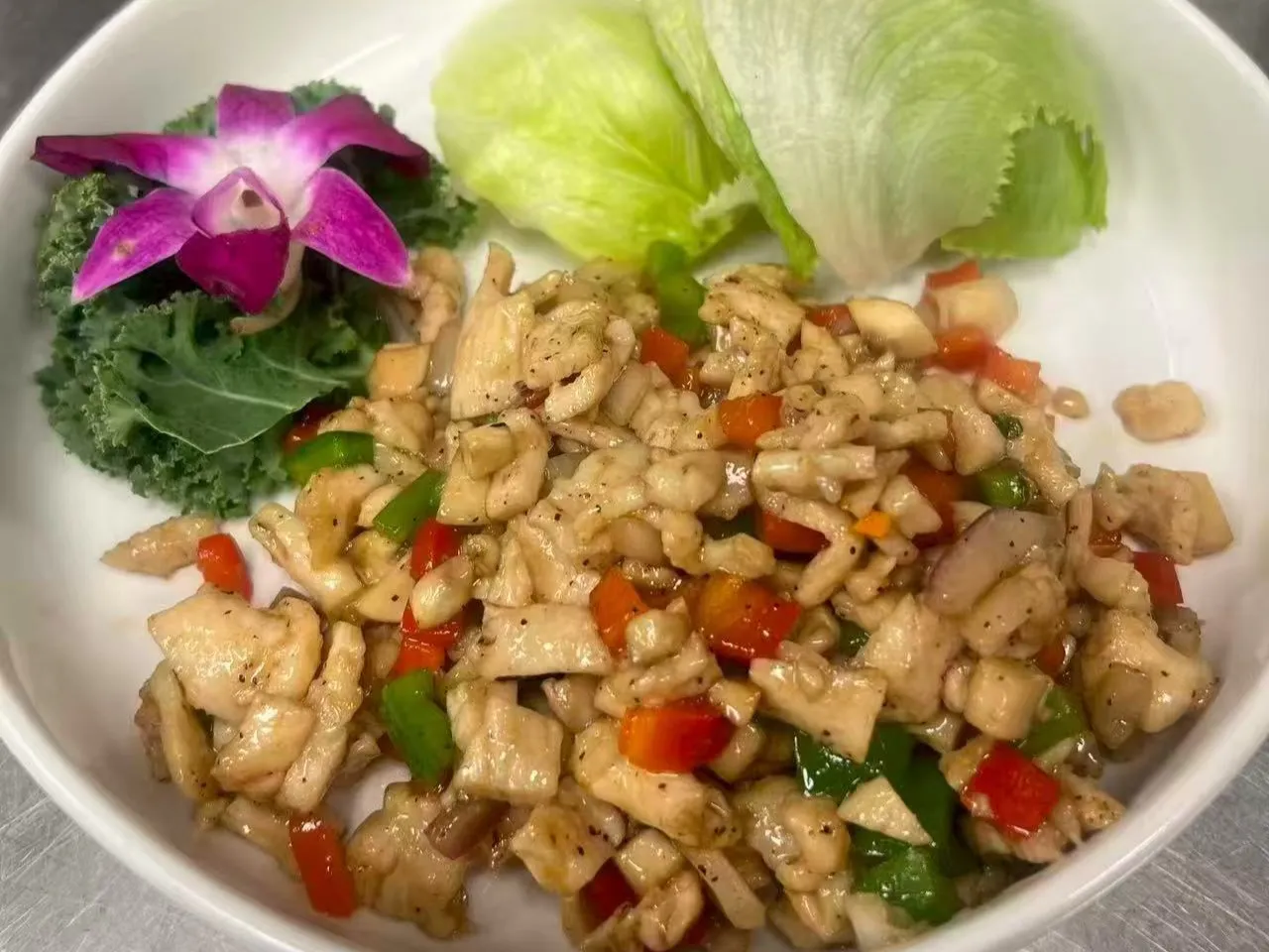 Diced chicken stir fry with bell peppers and decorative orchid at Chengdu Impression Chinese Restaurant in Schenectady