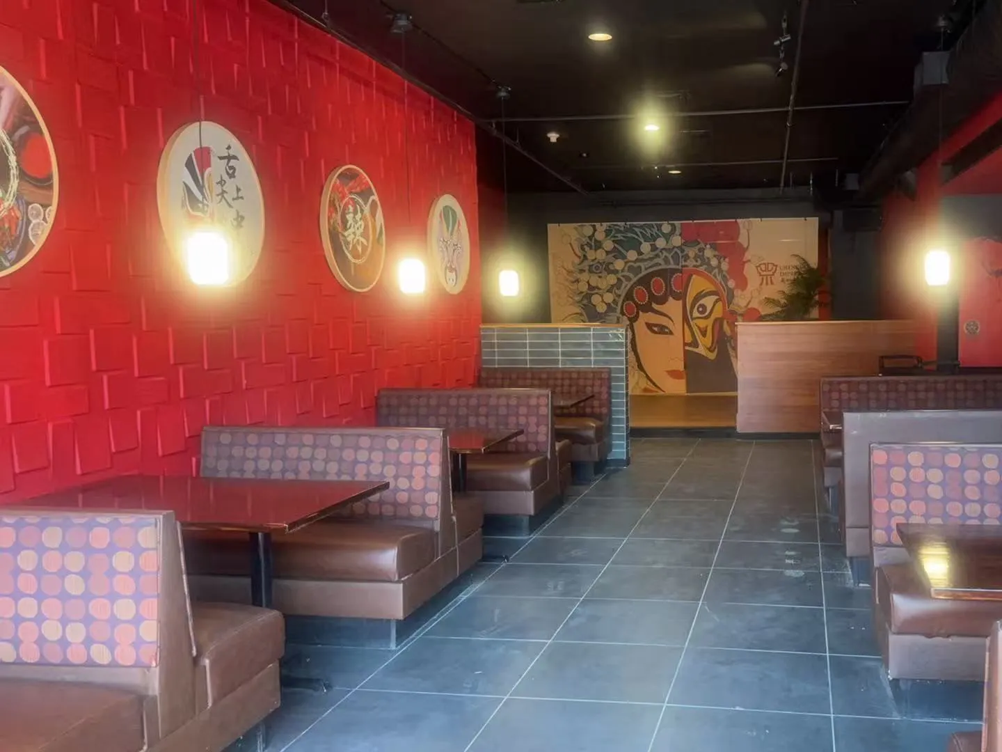 Dining room interior with red textured walls and opera mask wall decor at Chengdu Impression Chinese Restaurant in Schenectady